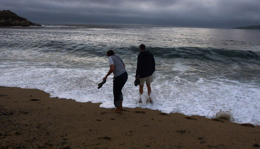 A couple walking along Monastary Beach.